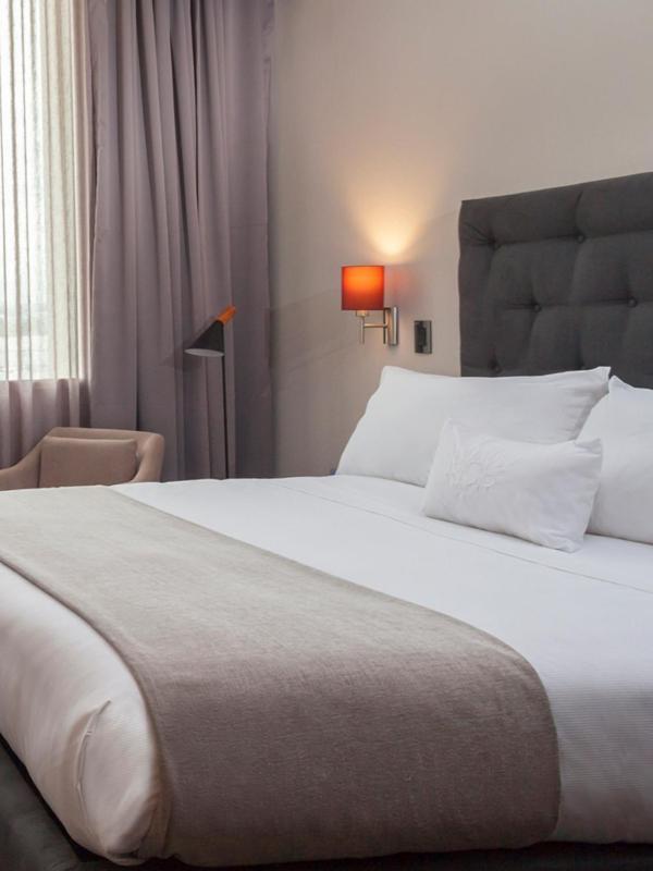 Mds Hotel Chillan Bagian luar foto A bed with a throw